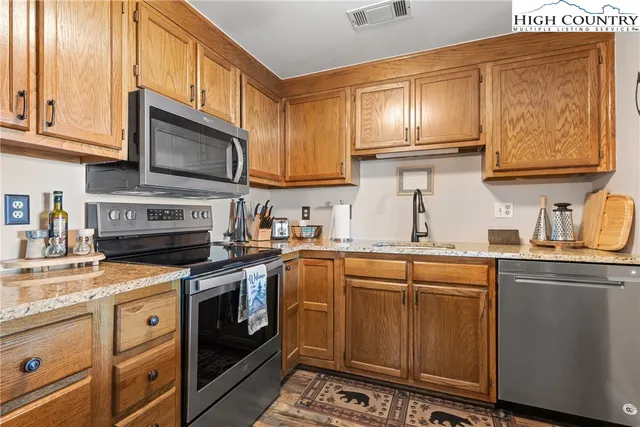 a kitchen with stainless steel appliances granite countertop a stove sink microwave and cabinets