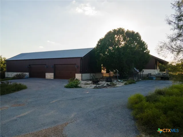 a view of a house with backyard and parking area