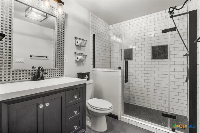 a bathroom with a sink a toilet and shower