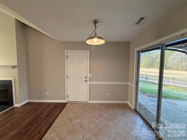a view of empty room with wooden floor and fireplace