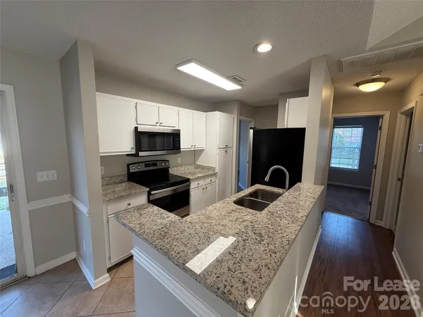 a kitchen with granite countertop stainless steel appliances and wooden cabinets