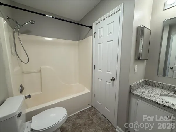 a bathroom with a granite countertop toilet sink and shower