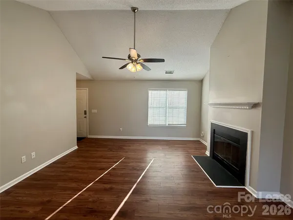 a view of an empty room with a fireplace and a window