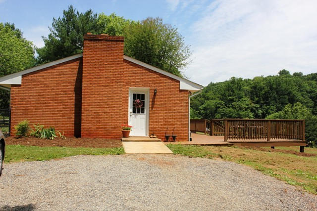 401 Monty Road Boones Mill, VA 24065 - Photo 27 of 30 a backyard of a house with large trees and outdoor seating