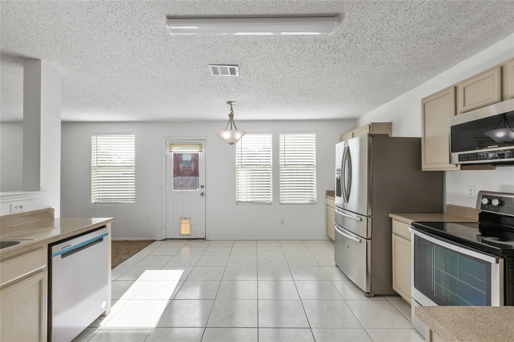 1628 Fieldstone Drive Little Elm, TX 75068 - Photo 13 of 32 a kitchen with stainless steel appliances granite countertop a refrigerator and a stove top oven