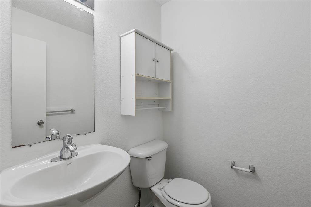 1628 Fieldstone Drive Little Elm, TX 75068 - Photo 14 of 32 a bathroom with a toilet a sink and mirror