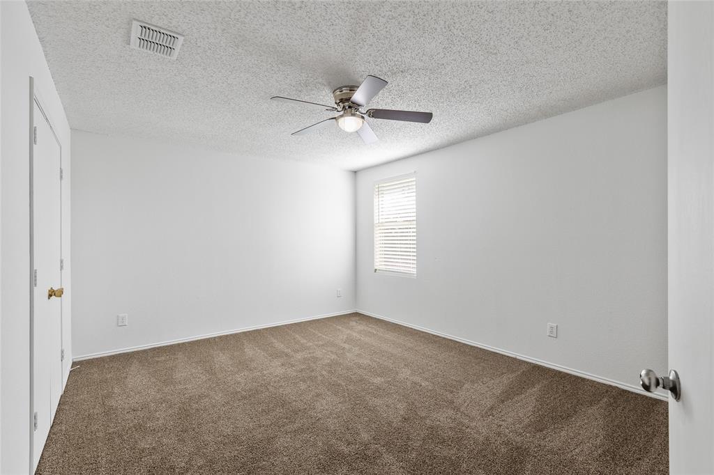 1628 Fieldstone Drive Little Elm, TX 75068 - Photo 23 of 32 an empty room with windows and fan