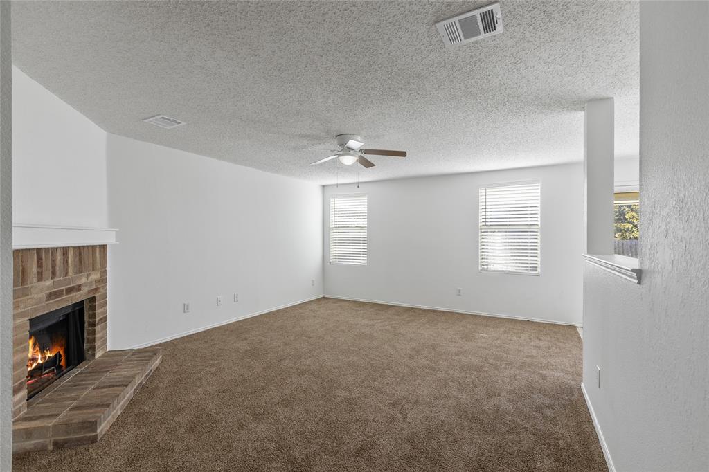 1628 Fieldstone Drive Little Elm, TX 75068 - Photo 9 of 32 an empty room with windows and fireplace