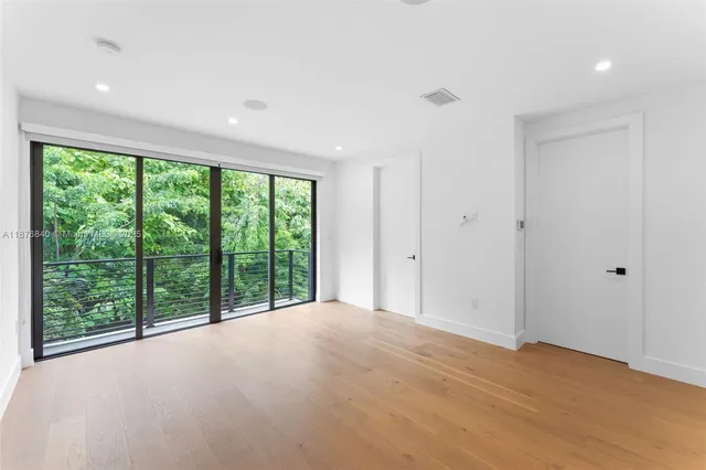 a view of a big room with wooden floor and windows