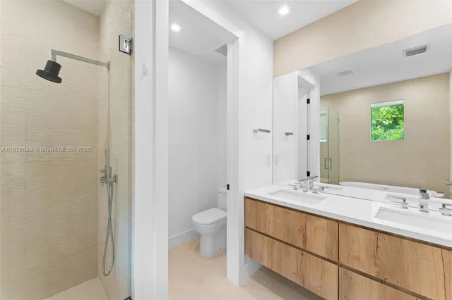 a bathroom with a double vanity sink toilet and shower