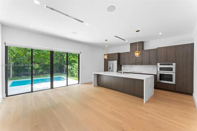 a large kitchen with stainless steel appliances a large counter top