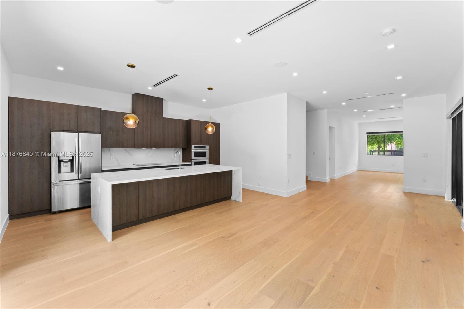 3132 Plaza Street Miami, FL 33133 - Photo 8 of 36 a kitchen with stainless steel appliances kitchen island a large counter top and a refrigerator