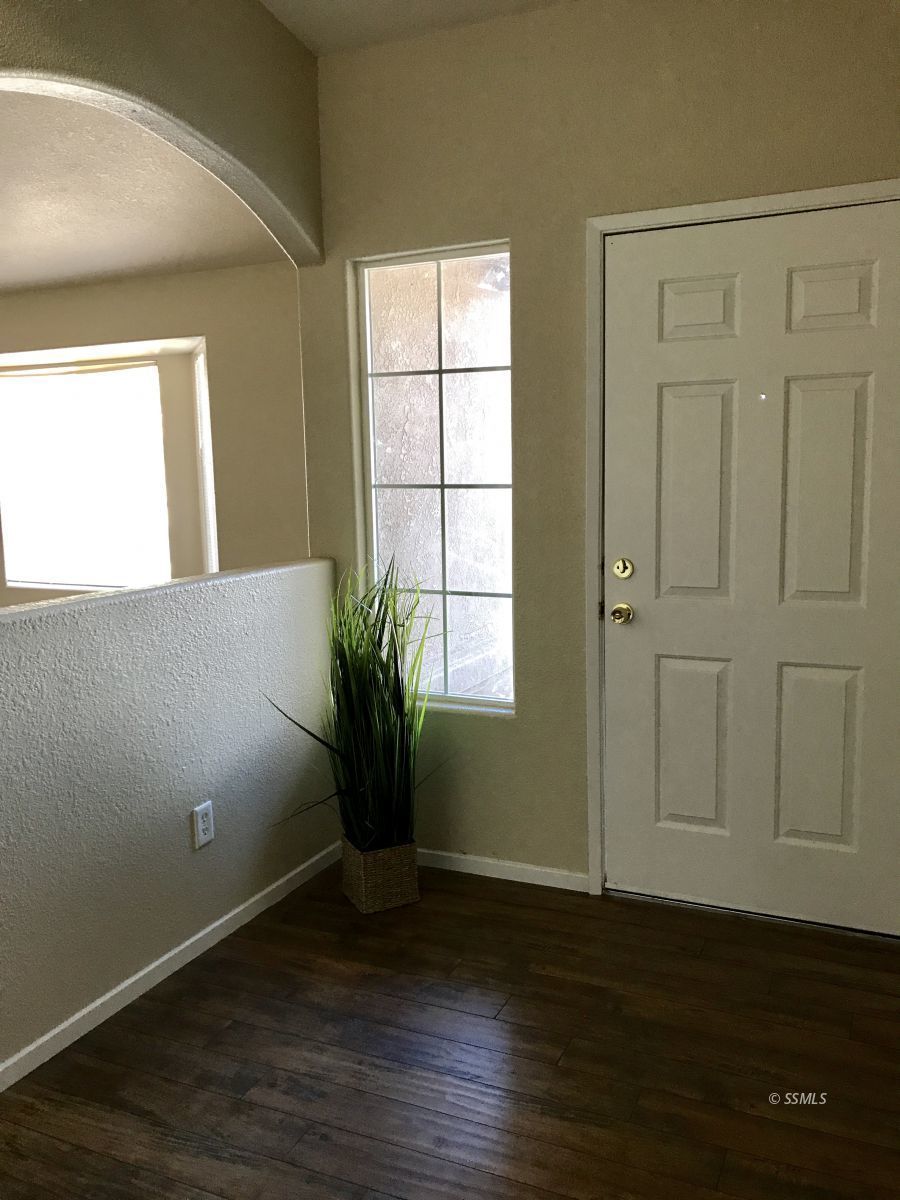 559 South Alvord Street Ridgecrest, CA 93555 - Photo 2 of 7 a view of an empty room with wooden floor and a window
