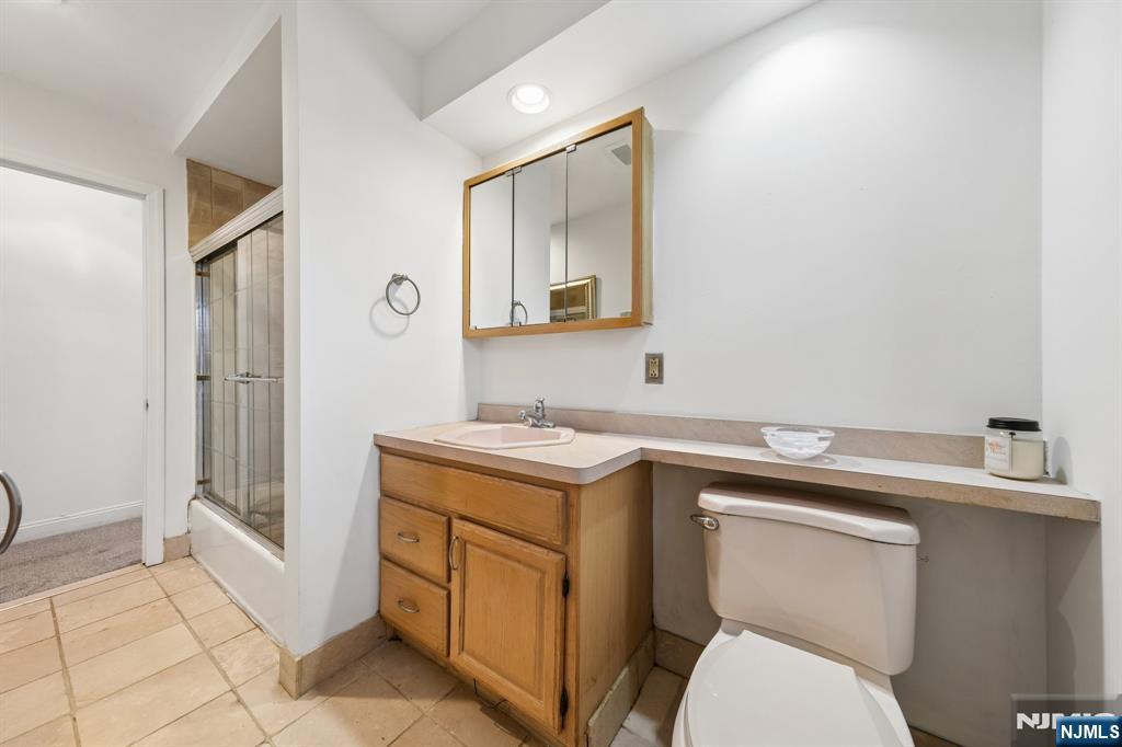 2 Caryn Place Fairfield, NJ 07004 - Photo 13 of 35 a bathroom with a toilet sink vanity and mirror