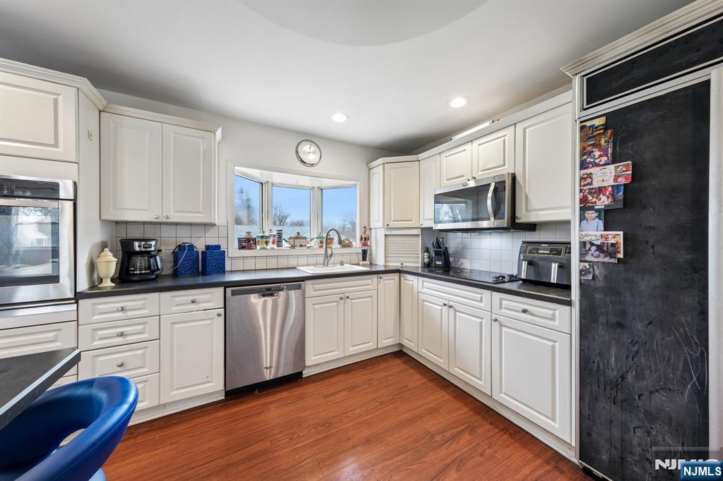 2 Caryn Place Fairfield, NJ 07004 - Photo 3 of 35 a kitchen with stainless steel appliances granite countertop a sink and cabinets