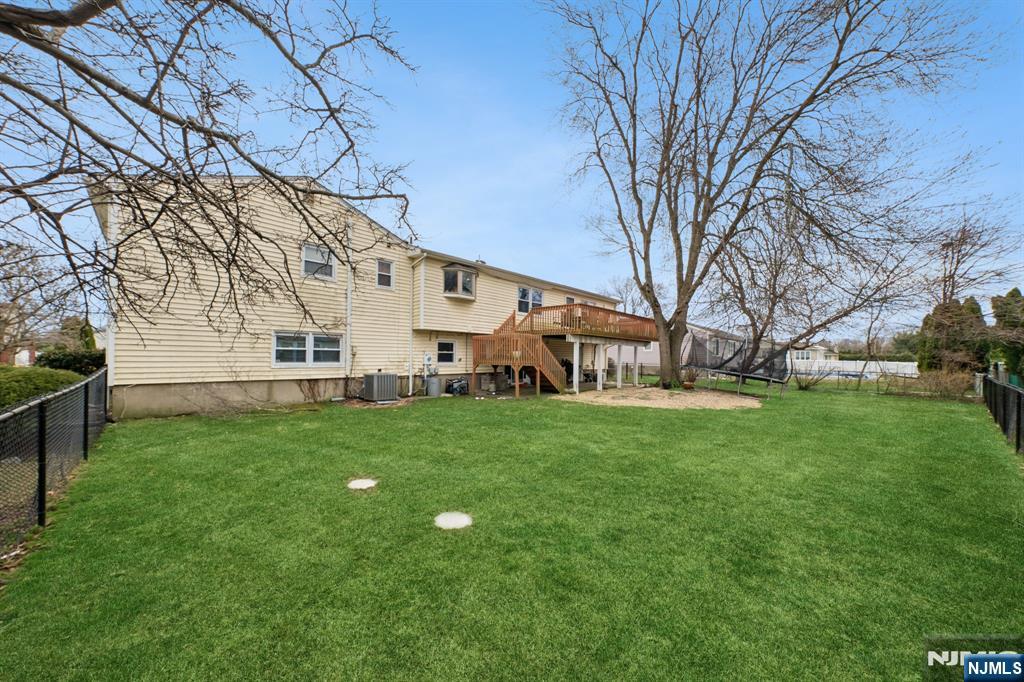 2 Caryn Place Fairfield, NJ 07004 - Photo 32 of 35 a view of a white house in front of a big yard with large trees