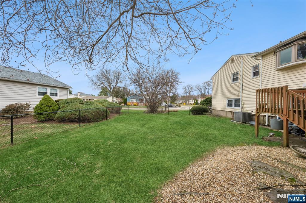 2 Caryn Place Fairfield, NJ 07004 - Photo 33 of 35 a backyard of a house with plants and large tree