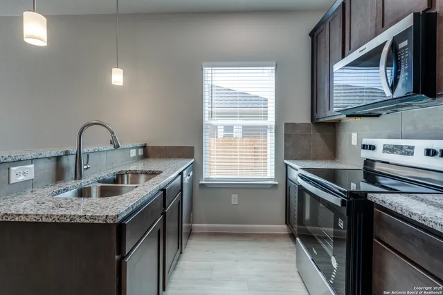 a bathroom with a granite countertop bathtub sink vanity mirror and toilet