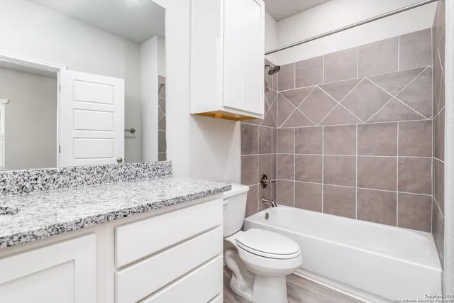 an empty room with wooden floor chandelier fan and windows