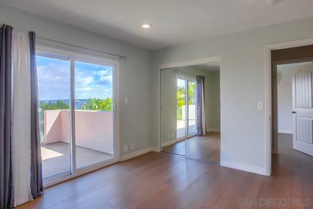 13495 Mango Drive Del Mar, CA 92014 - Photo 44 of 53 a view of a hallway to an empty room with wooden floor and a window