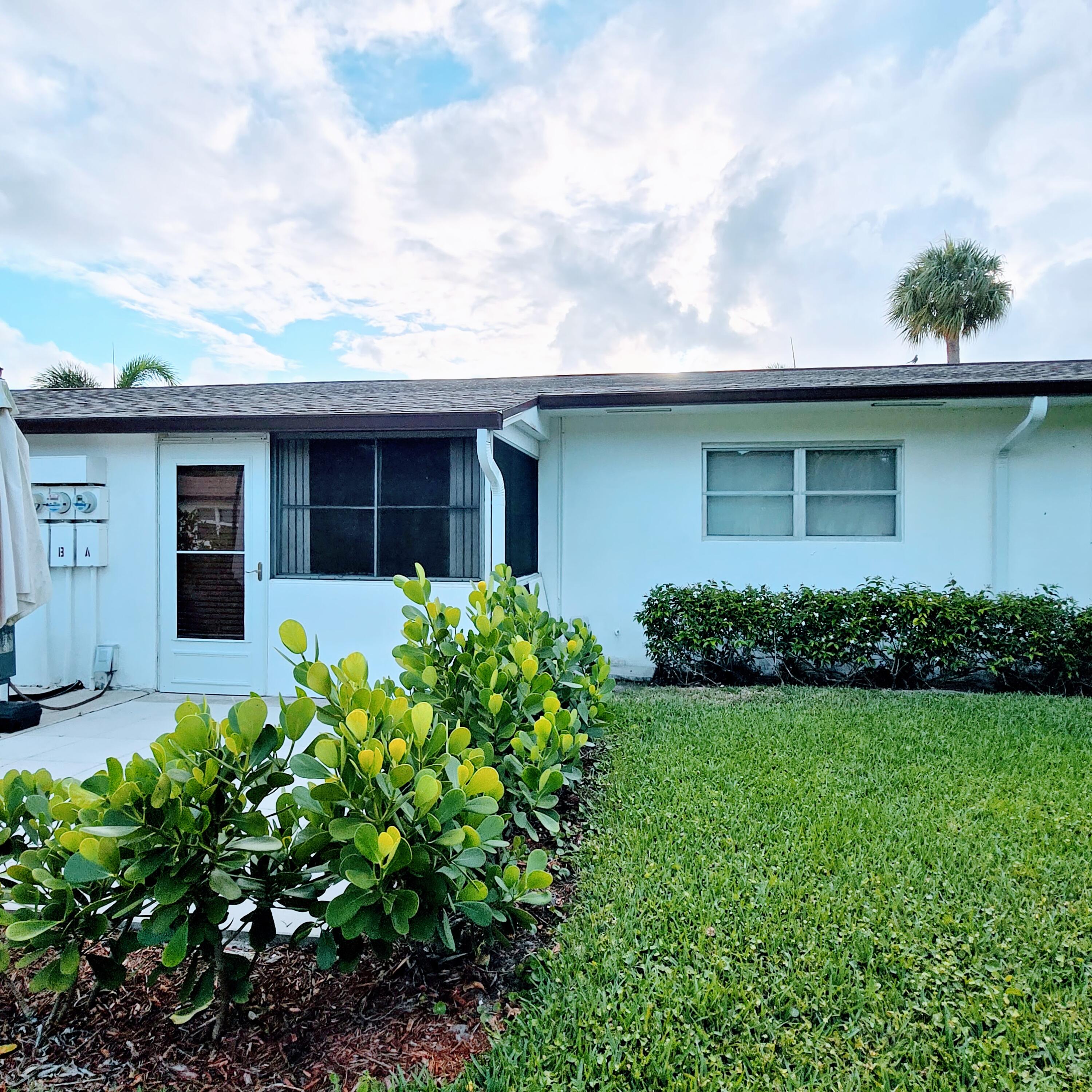 2930 Crosley Drive East, Unit C West Palm Beach, FL 33415 - Photo 13 of 21 a front view of a house with garden