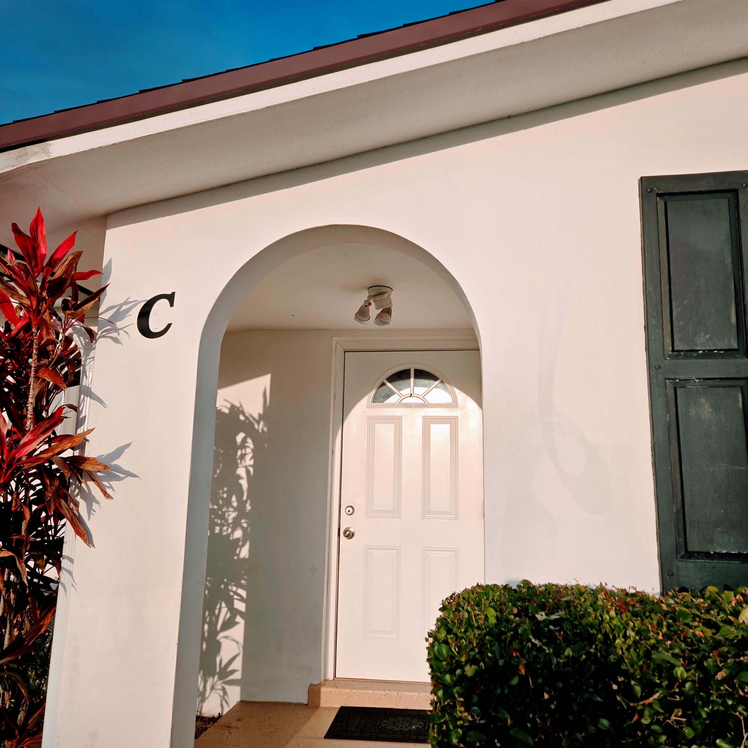 2930 Crosley Drive East, Unit C West Palm Beach, FL 33415 - Photo 14 of 21 a front view of a house with garden