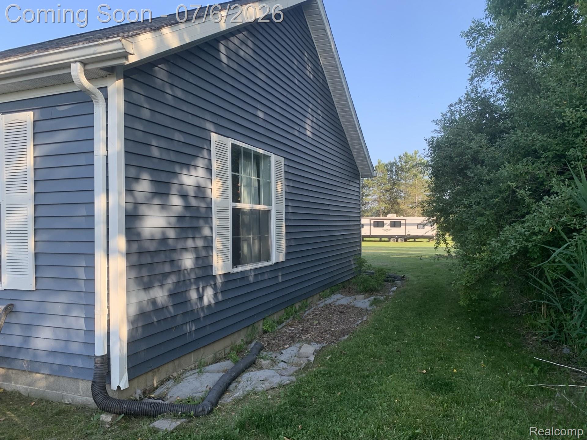 4168 Harris Road Fort Gratiot, MI 48059 - Photo 8 of 30 Blue horizontal siding exterior with white window trim and decorative shutters