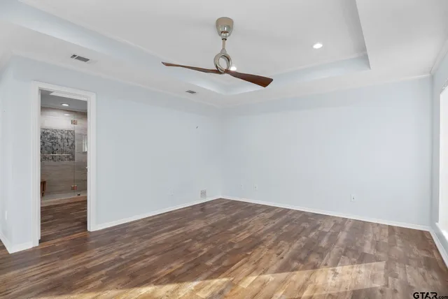 a view of a room with wooden floor and ceiling fan