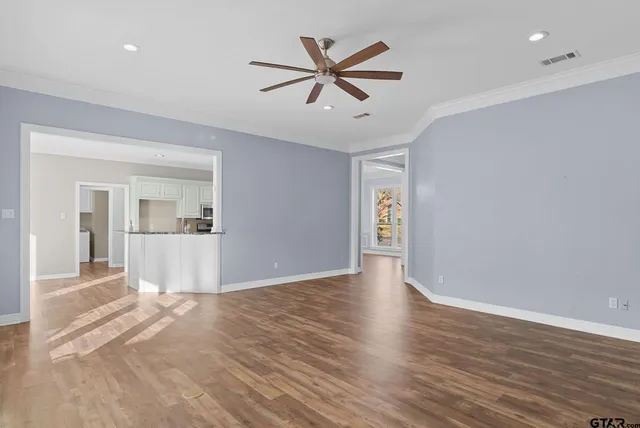a view of a livingroom with wooden floor and a ceiling fan