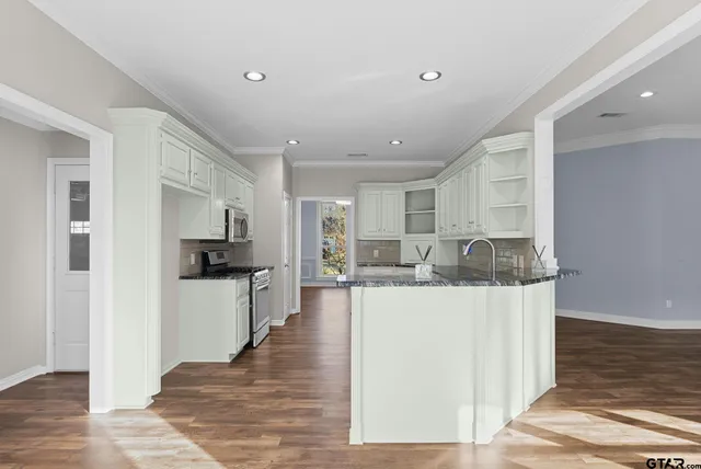 a view of a kitchen with kitchen island stainless steel appliances refrigerator stove microwave and cabinets