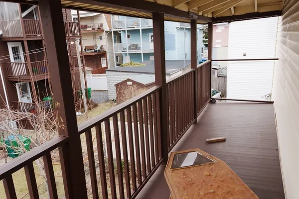 a view of a balcony with wooden floor and iron stairs