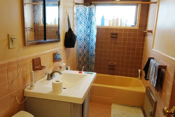 a bathroom with a sink and mirror with bathtub