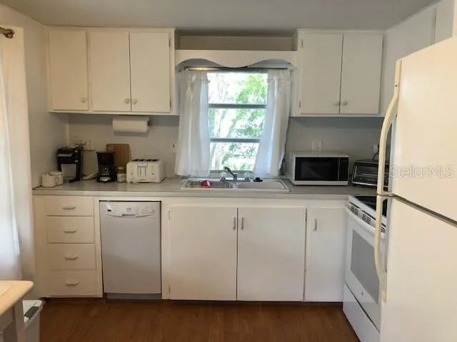 a kitchen with white cabinets and white appliances
