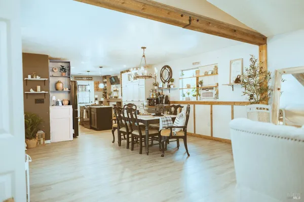 a large white kitchen with a dining table chairs and a refrigerator