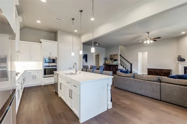 a large white kitchen with a large window and stainless steel appliances