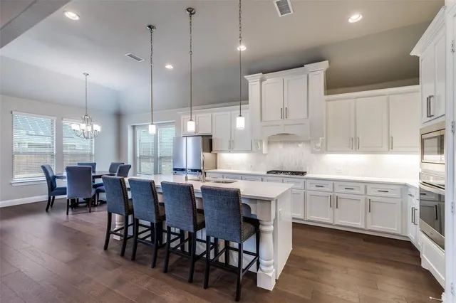 a kitchen with lots of counter space dining table and stainless steel appliances