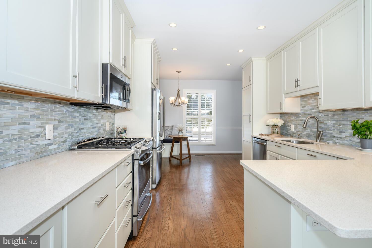 320 Perry Cabin Drive St. Michaels, MD 21663 - Photo 11 of 50 a kitchen with stainless steel appliances white cabinets sink and wooden floor