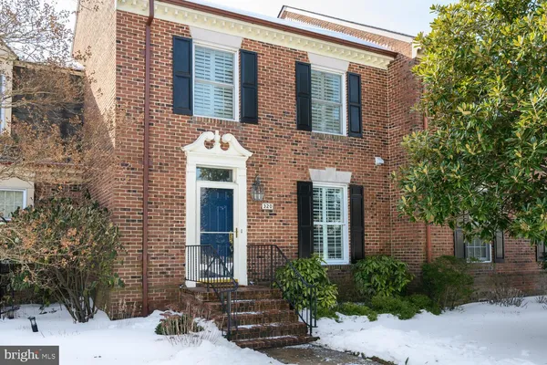 front view of a brick house with a small yard