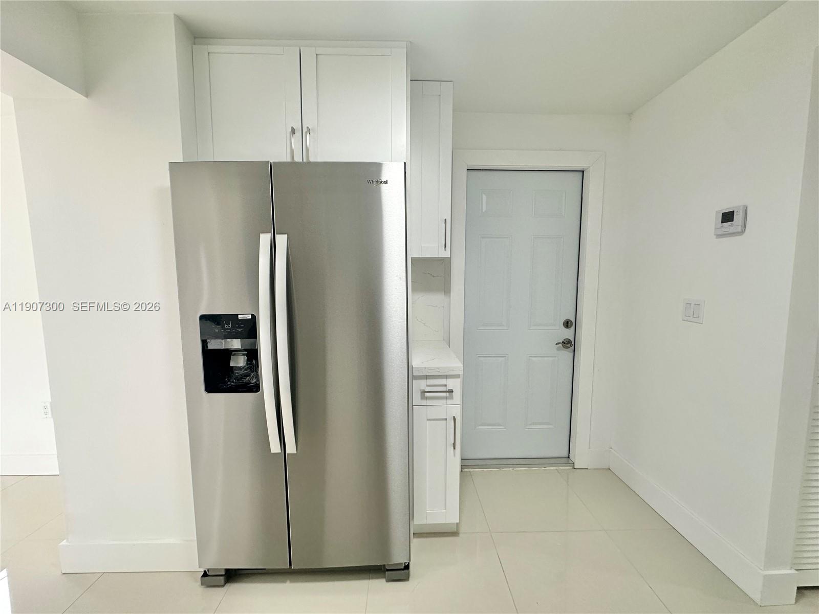 5740 Freedom Street Hollywood, FL 33021 - Photo 22 of 43 a view of a refrigerator in kitchen and white cabinets