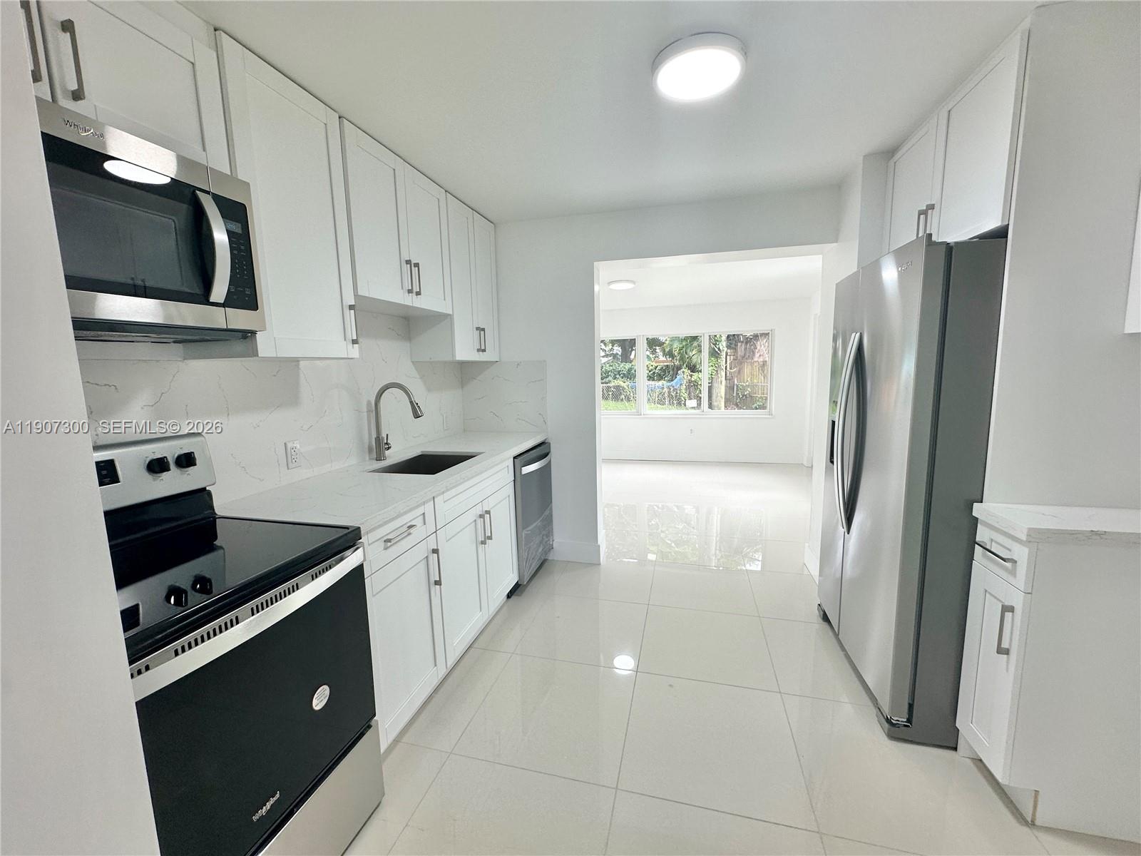 5740 Freedom Street Hollywood, FL 33021 - Photo 24 of 43 a kitchen with stainless steel appliances a refrigerator sink and microwave