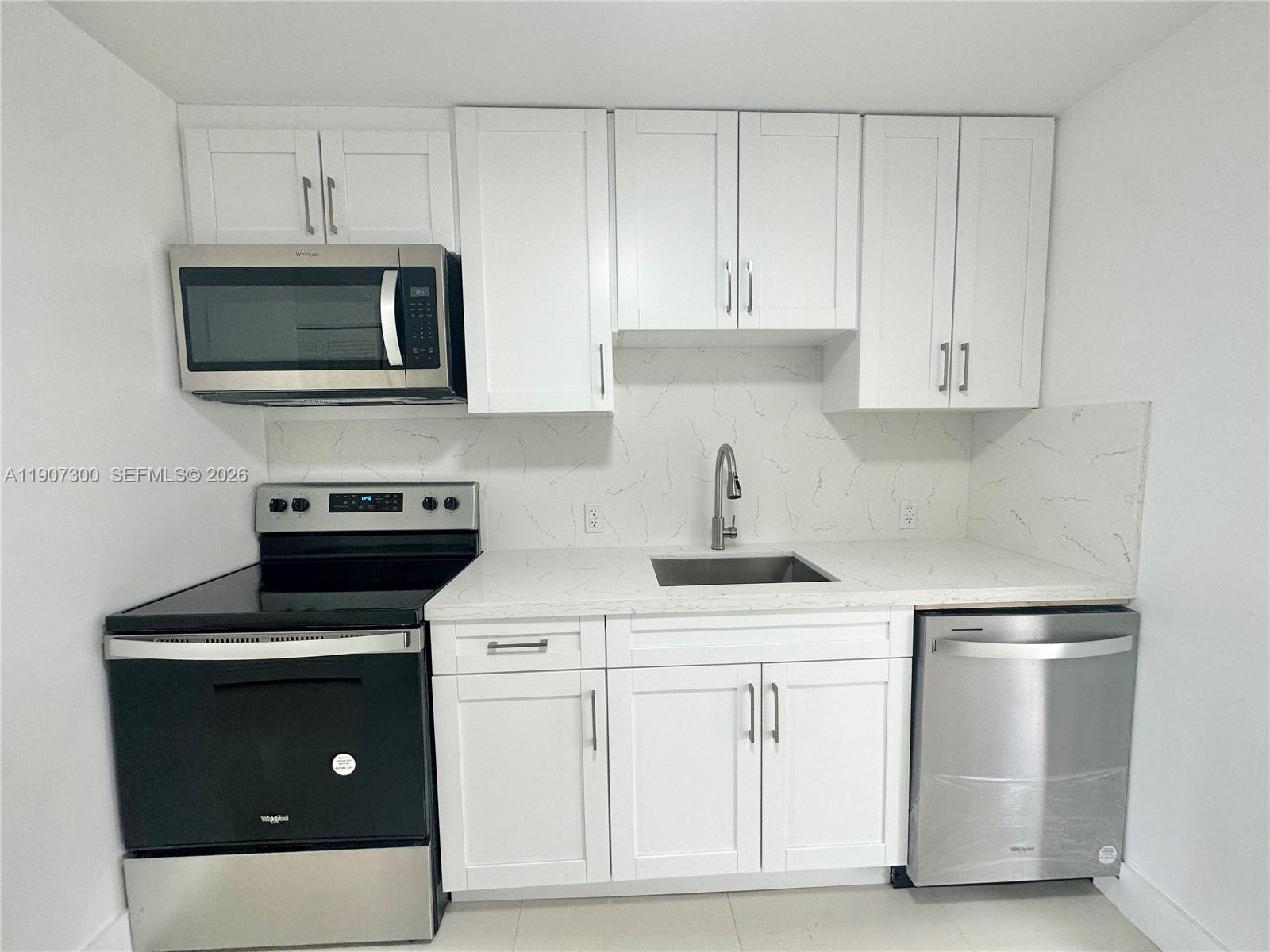 5740 Freedom Street Hollywood, FL 33021 - Photo 25 of 43 a kitchen with white cabinets and stainless steel appliances