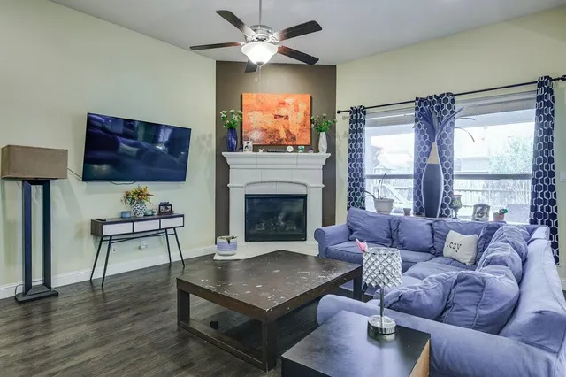 a living room with furniture a flat screen tv and a fireplace
