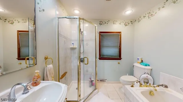 a bathroom with a sink vanity granite tub and shower