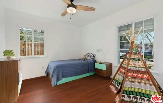 a bedroom with a bed and wooden floor