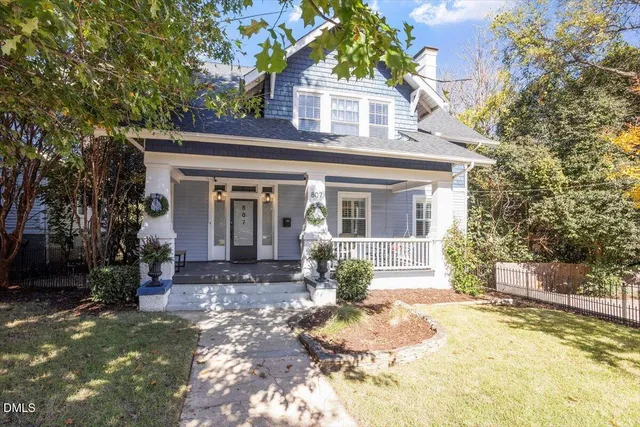 a front view of a house with a yard and potted plants