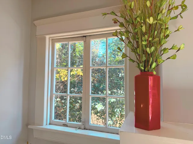a bedroom with a bed and a dresser next to a window