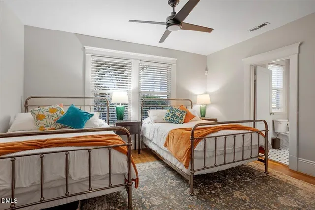 a bedroom with two beds and window