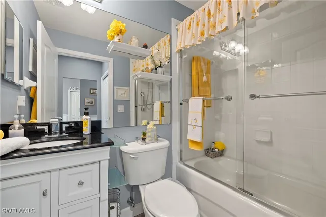 a bathroom with a sink a toilet a mirror and shower