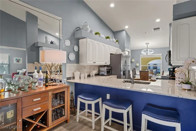 a kitchen with a sink stove and white cabinets with wooden floor