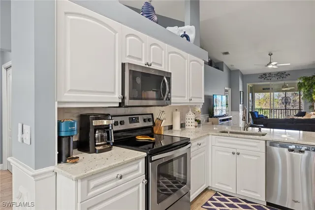 a kitchen with stainless steel appliances a white stove top oven and white cabinets